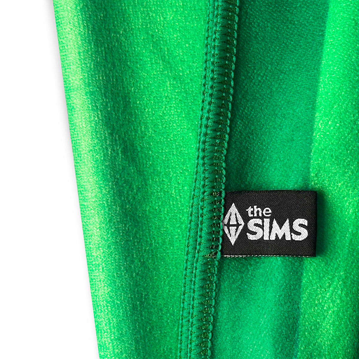 Close-up of a bright green fleece zipper with a black fabric patch featuring the white 'the SIMS' logo.