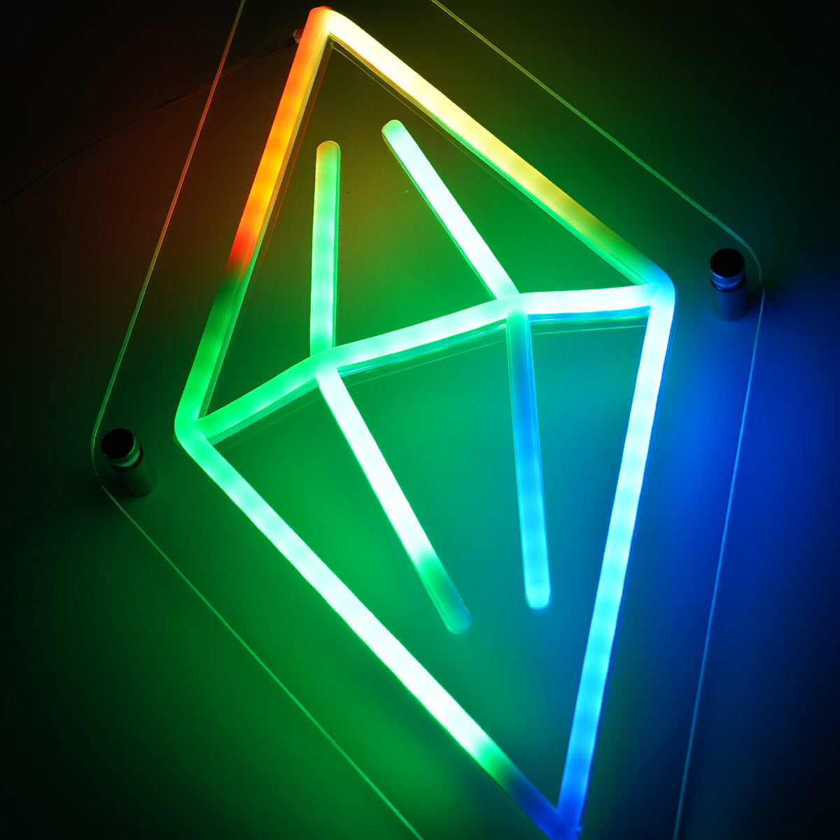 Neon light sculpture in the shape of a geometric figure with multicolors on a dark background